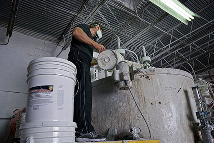 Owner blending the liquid rubber coating base at The Roof Store factory in Davie Florida